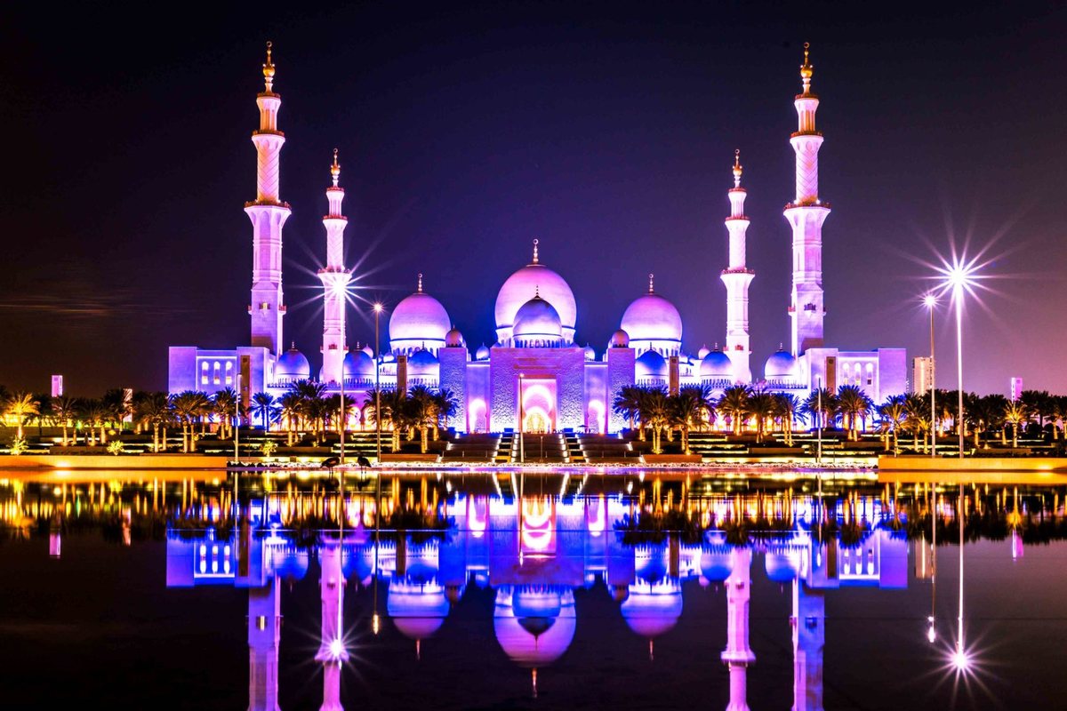 Sheikh Zayed Grand Mosque at night, lit in white and blue